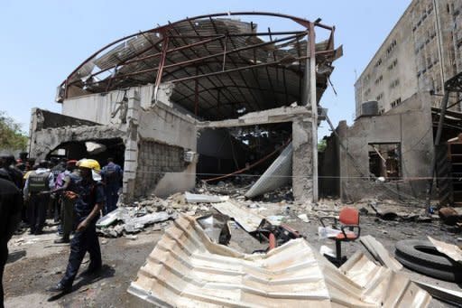 A firefighter stands in front of the office of ThisDay newspaper in Abuja. A suicide attack at the Abuja bureau of a top Nigerian newspaper and an attempted car bombing at another of its offices killed nine people Thursday in the first such strikes on the country's media