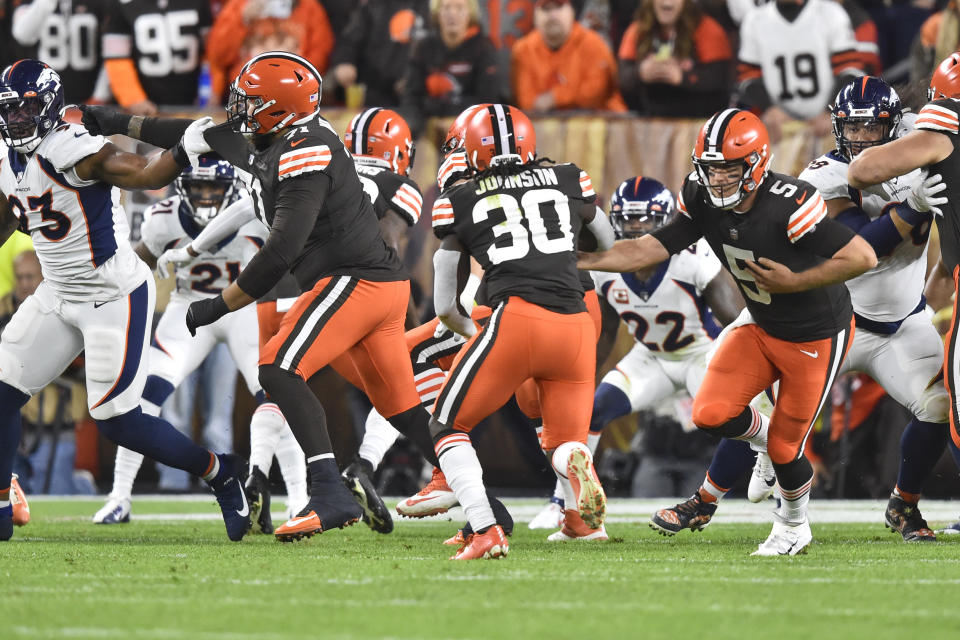 Cleveland Browns quarterback Case Keenum (5) hands the ball off to running back D'Ernest Johnson (30) for a 4-yard touchdown during the first half of the team's NFL football game against the Denver Broncos, Thursday, Oct. 21, 2021, in Cleveland. (AP Photo/David Richard)