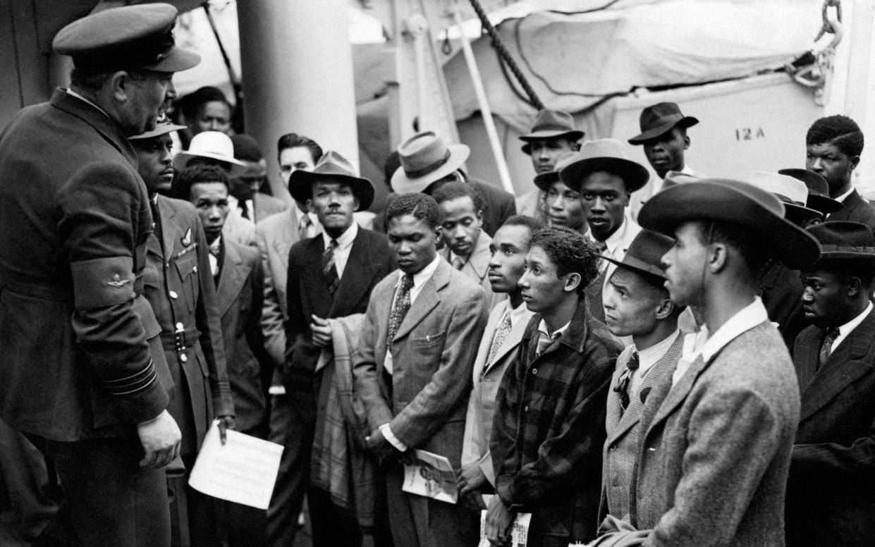 Jamaican immigrants are welcomed by RAF officials from the Colonial Office after the ex-troopship HMT Empire Windrush brought them to Tilbury, in Essex - PA 