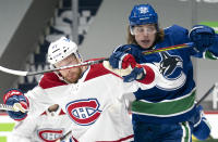 Vancouver Canucks centre Adam Gaudette (96) and Montreal Canadiens defenceman Brett Kulak (77) fight for control of the puck during second period NHL action in Vancouver, Monday, March 8, 2021. (Jonathan Hayward/The Canadian Press via AP)