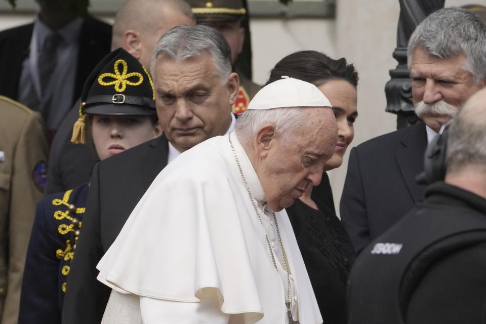 Pope Francis and Hungary President Katalin Novák walk past Hungary Prime Minister Viktor Orban, left, in the square of "Sándor" Palace in Budapest, Friday, April 28, 2023. The Pontiff is in Hungary for a three-day pastoral visit. (AP Photo/Andrew Medichini)