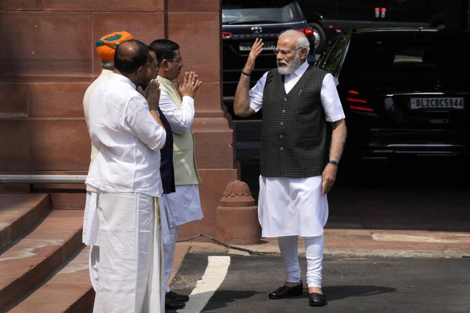 Indian Prime Minister Narendra Modi talks to his cabinet colleagues upon arrival on the opening day of the monsoon session of the Indian parliament in New Delhi, India, Thursday, July 20, 2023. Modi Thursday broke more than two months of his public silence over the deadly ethnic clashes that have marred the country's remote northeast Manipur state, a day after a viral video showed two women being paraded naked by a mob, sparking outrage across the nation. (AP Photo/Manish Swarup)
