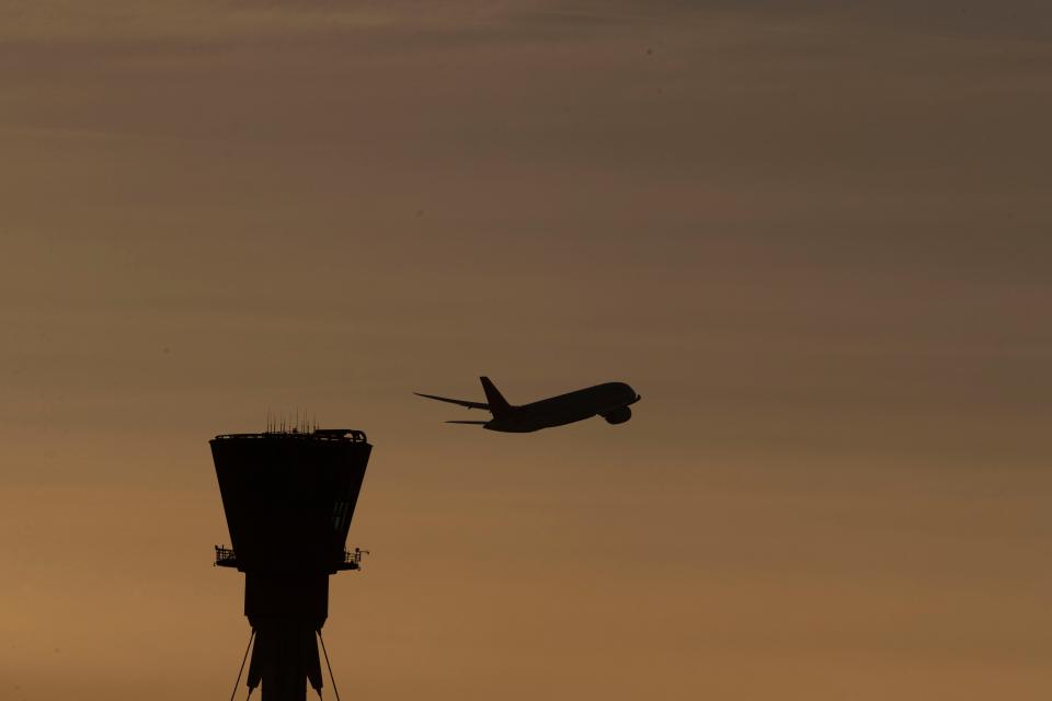 A plane takes off past the control tower at Heathrow Airport (Steve Parsons/PA) (PA Archive)