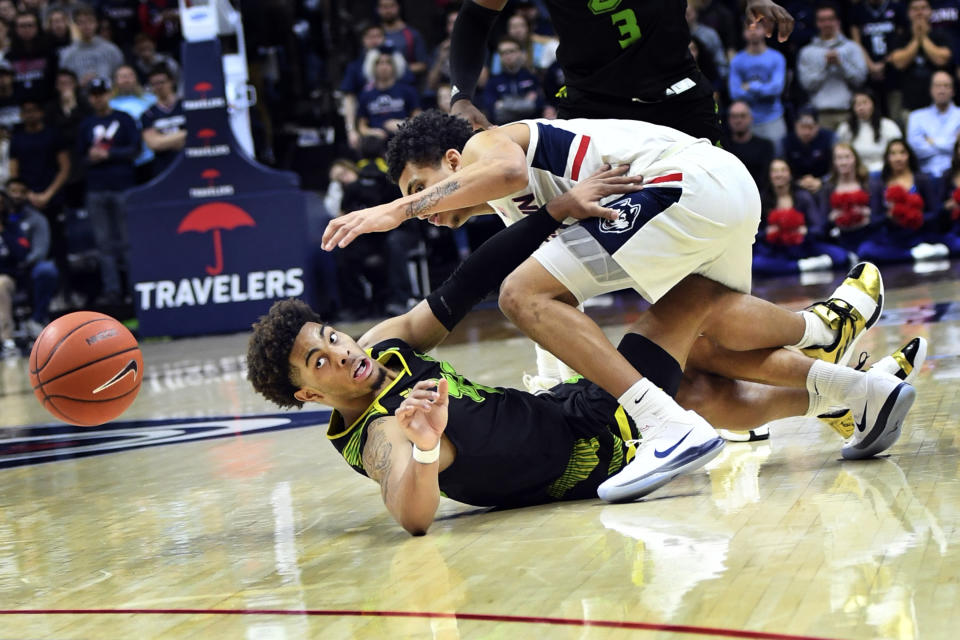 Connecticut's James Bouknight (2) and South Florida's David Collins (0) battle for the ball during the second half of an NCAA college basketball game Sunday, Feb. 23, 2020, in Storrs, Conn. (AP Photo/Stephen Dunn)