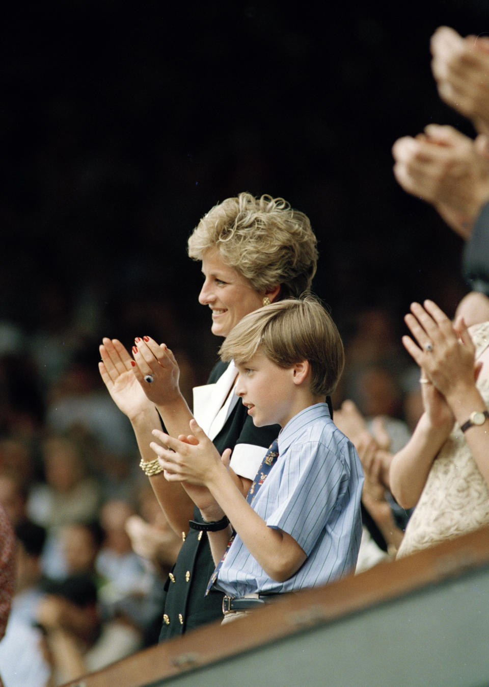 ARCHIVO - La princesa Diana y su hijo, el príncipe Guillermo, aplauden durante las presentaciones del Campeonato de Tenis Femenino de Wimbledon después de la final, el 1 de julio de 1994. (Foto AP/Gill Allen, archivo)