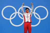 <p>Gold medallist China's Xie Siyi points to the sky as he steps up to the podium after winning the men's 3m springboard diving final at the Tokyo Aquatics Centre on August 3.</p>