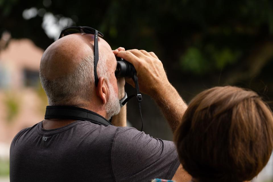 Sean Murray uses his binoculars to try and see Air Force One outside of the Roland R. Wright Air National Guard Base in Salt Lake City on Wednesday, Aug. 9, 2023. | Megan Nielsen, Deseret News