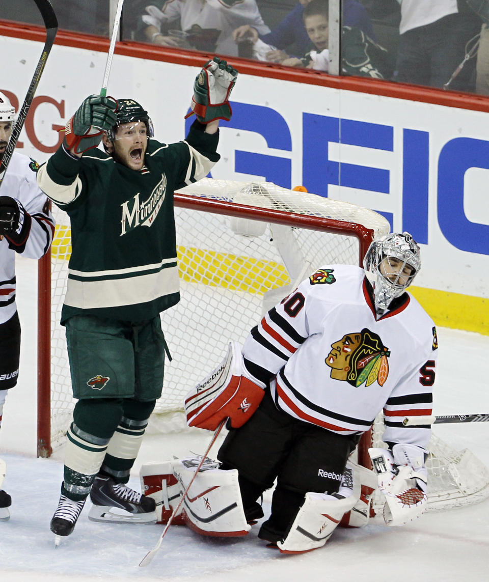 Minnesota Wild left wing Matt Cooke, left, celebrates after Wild right wing Justin Fontaine scored on Chicago Blackhawks goalie Corey Crawford, right, during the first period of Game 4 of an NHL hockey second-round playoff series in St. Paul, Minn., Friday, May 9, 2014. (AP Photo/Ann Heisenfelt)