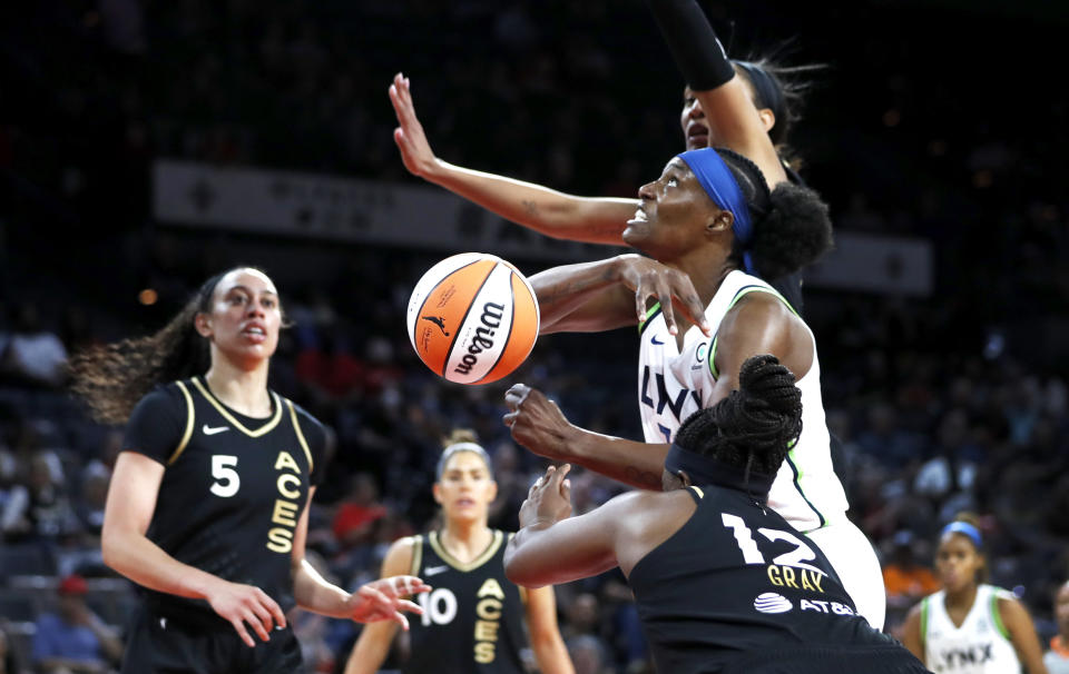 Minnesota Lynx center Sylvia Fowles fights for a rebound between Las Vegas Aces forward A'ja Wilson and guard Chelsea Gray (12) during a WNBA basketball game in Las Vegas on Thursday, May 19, 2022. (Steve Marcus/Las Vegas Sun via AP)