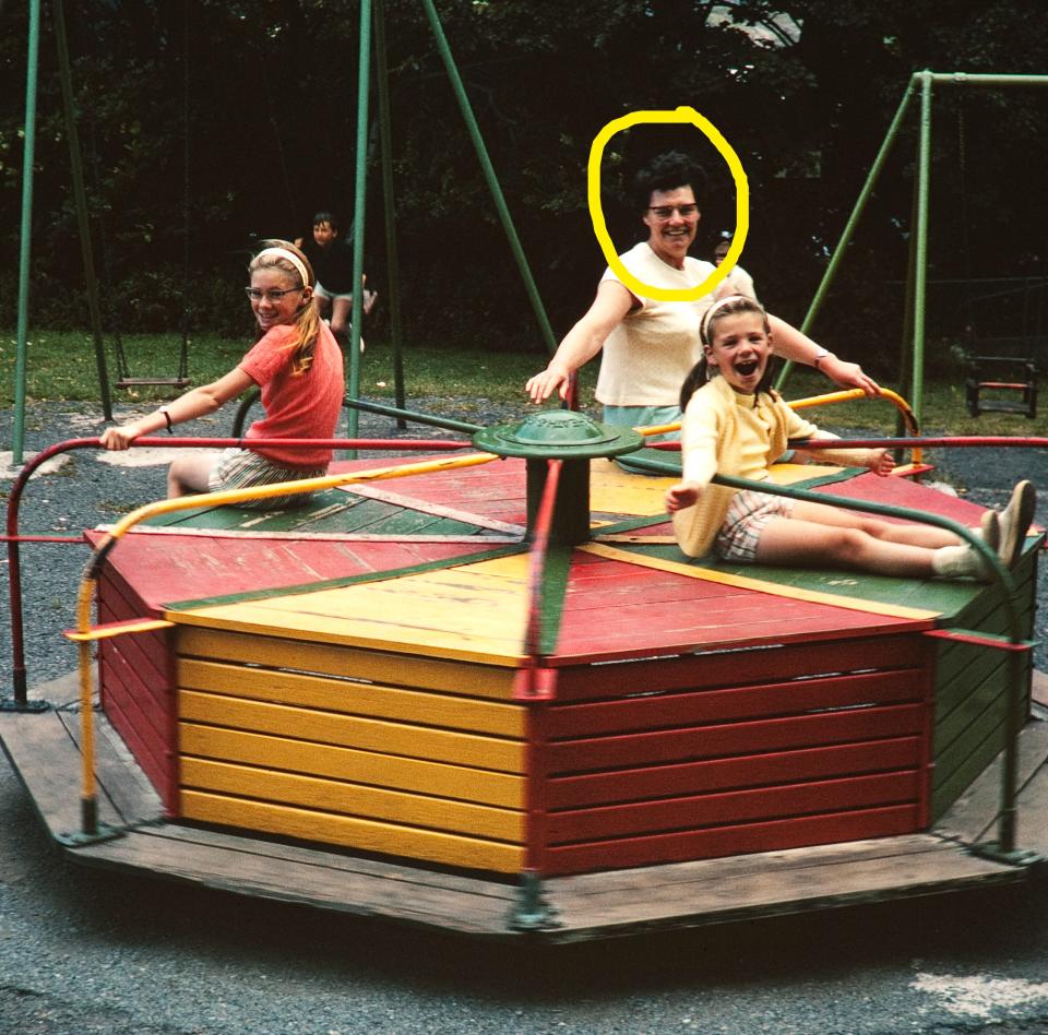 People on a playground merry-go-round, enjoying a ride