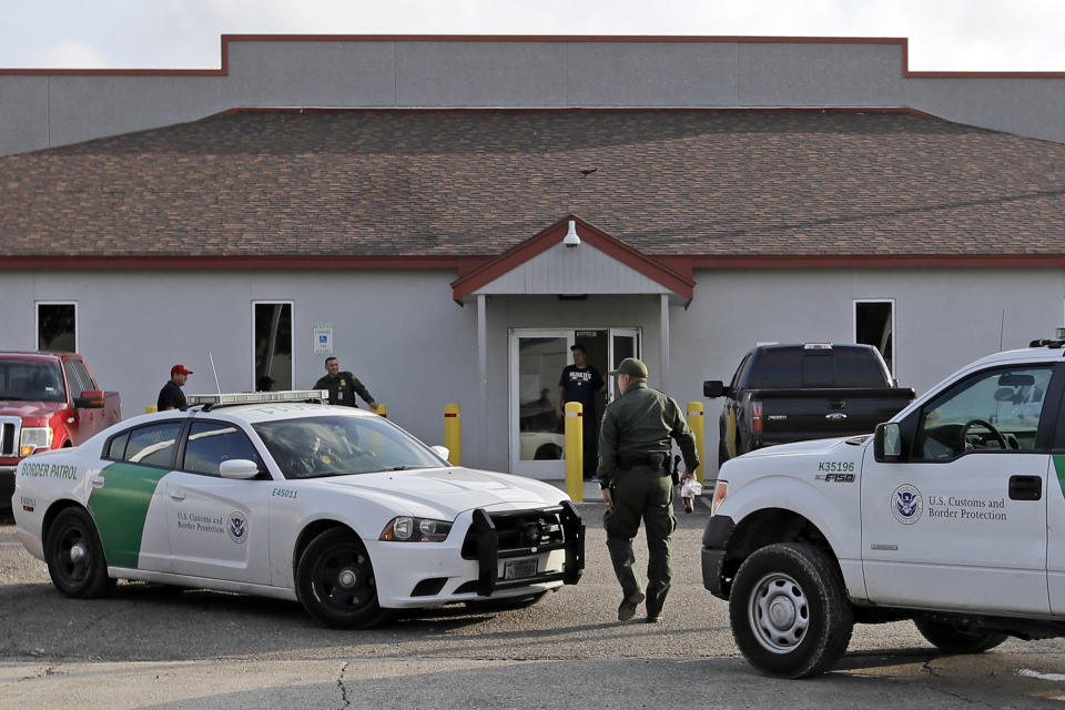 FILE - In this June 23, 2018, file photo, a U.S. Border Patrol Agent walks between vehicles outside the Central Processing Center in McAllen, Texas. A report released Tuesday, July 2, 2019, by the Department of Homeland Security’s Office of Inspector General warns that facilities in South Texas’ Rio Grande Valley, including the CPC in McAllen, face “serious overcrowding” and require “immediate attention.” (AP Photo/David J. Phillip, File)