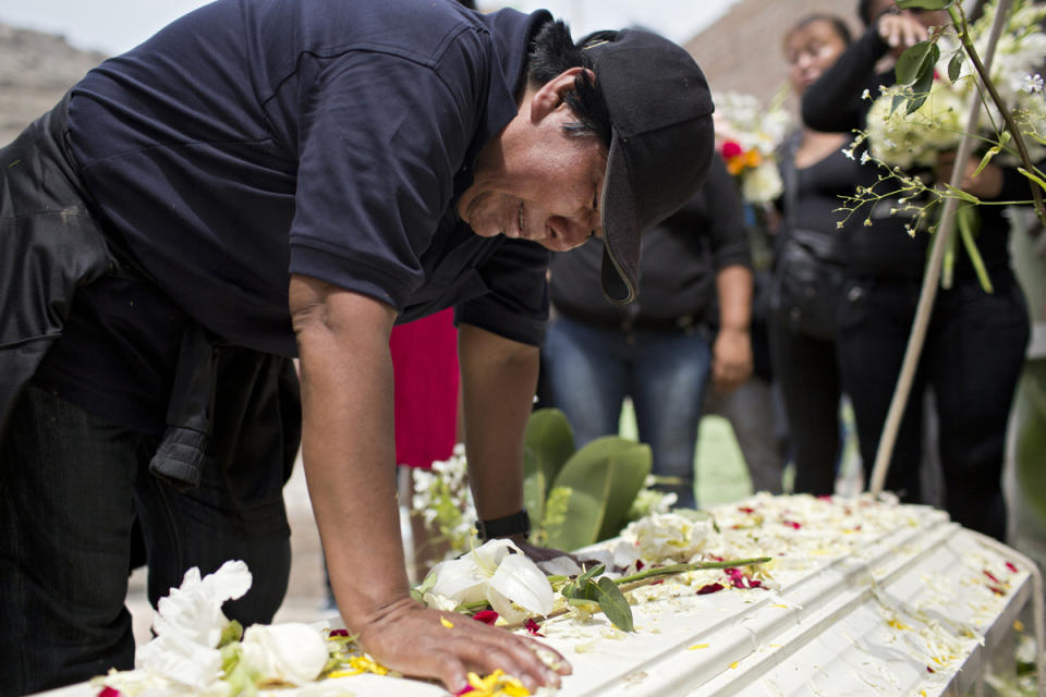 <p>Evila cries and talks to Tamara before her coffin is placed in the grave. (Photo: Danielle Villasana) </p>