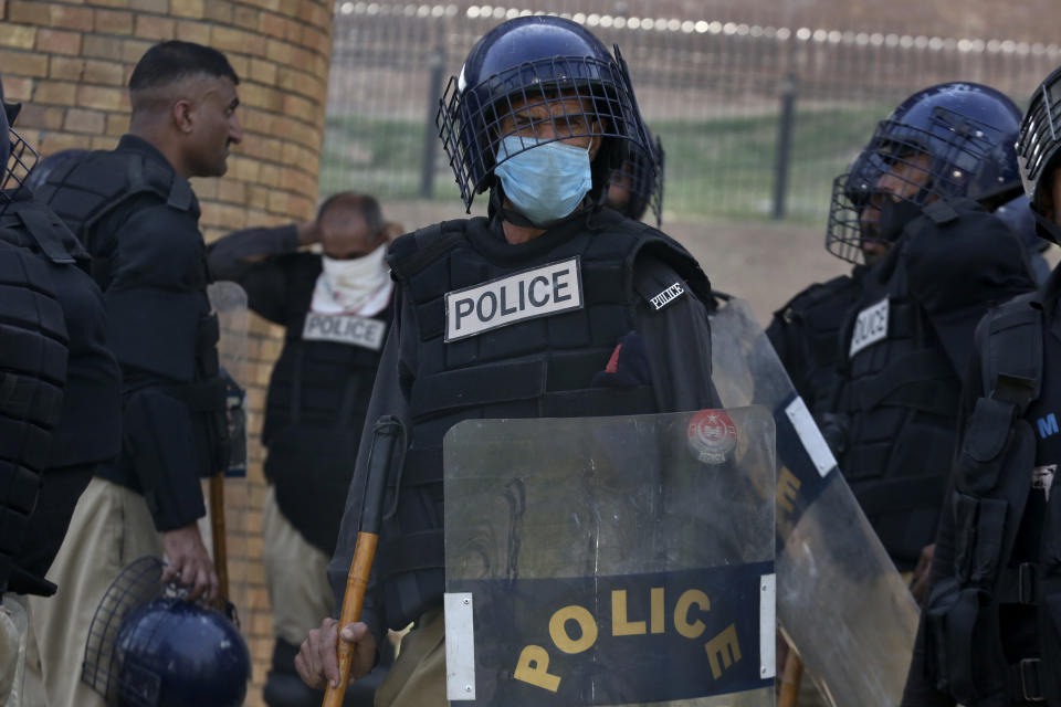 Police officers with riot gears stand alert to ensure security, in Peshawar, Pakistan, Thursday, May 11, 2023. With former Prime Minister Imran Khan in custody, Pakistani authorities on Thursday cracked down on his supporters, arresting hundreds in overnight raids and sending troops across the country to rein in the wave of violence that followed his arrest. (AP Photo/Muhammad Sajjad)