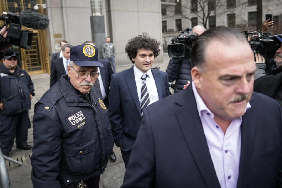 Samuel Bankman-Fried, center, departs Manhattan federal court in New York, Thursday, Feb. 9, 2023, in New York. (AP Photo/John Minchillo)