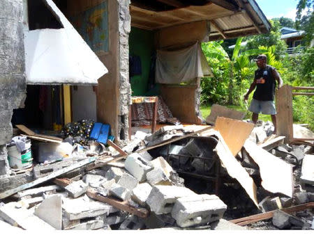 A man stands alongside a building belonging to the World Vision aid organisation that was damaged by an earthquake in Kirakira on the Solomon Islands, December 9, 2016. World Vision/Handout via REUTERS