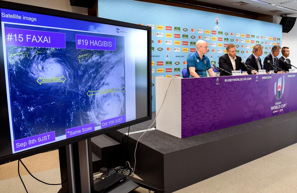 TOPSHOT - Tournament director of the Japan 2019 Rugby World Cup Alan Gilpin (2nd L) speaks to the media as a screen shows the the path of the approaching typhoon Hagibis, which will affect upcoming World Cup matches, in Tokyo on October 10, 2019. - Rugby World Cup organisers took the unprecedented step of cancelling games -- England v France, and New Zealand v Italy -- on October 10 as Super Typhoon Hagibis bears down on Japan. (Photo by William WEST / AFP) (Photo by WILLIAM WEST/AFP via Getty Images)