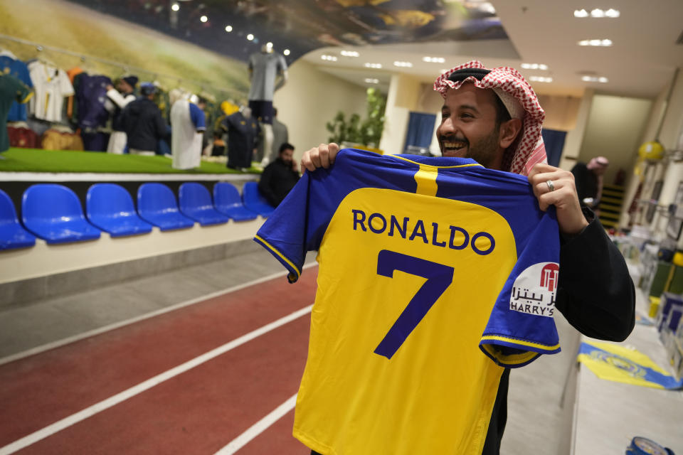 A man holds up Cristiano Ronaldo jerseys at Al Nassr soccer club store in Riyadh, Saudi Arabia, Monday, Jan 2, 2023. Ronaldo completed a lucrative move to Saudi Arabian club Al Nassr on Friday in a deal that is a landmark moment for Middle Eastern soccer but will see one of Europe's biggest stars disappear from the sport's elite stage. (AP Photo/Amr Nabil)