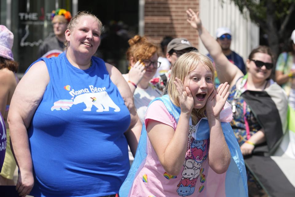 Flower Nichols cheers during the Pride Parade, Saturday, June 10, 2023, in Indianapolis. Families around the U.S. are scrambling to navigate new laws that prohibit their transgender children from accessing gender-affirming care. (AP Photo/Darron Cummings)