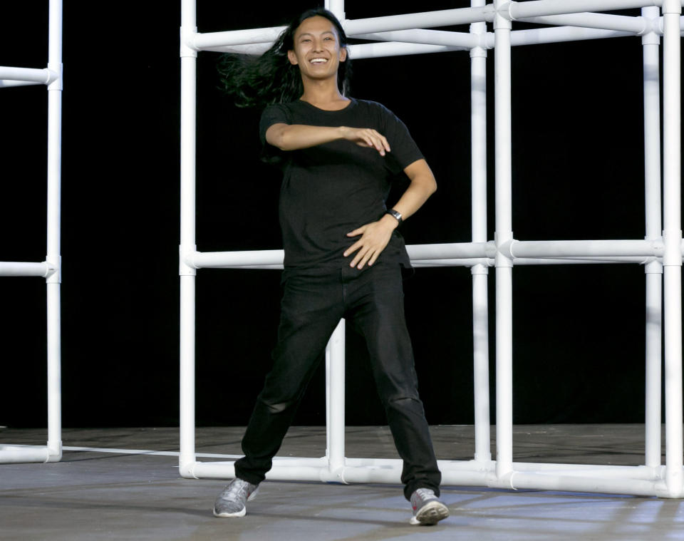 Designer Alexander Wang acknowledges audience applause after his Spring 2014 collection was modeled during Fashion Week in New York, Saturday, Sept. 7, 2013. (AP Photo/Richard Drew)