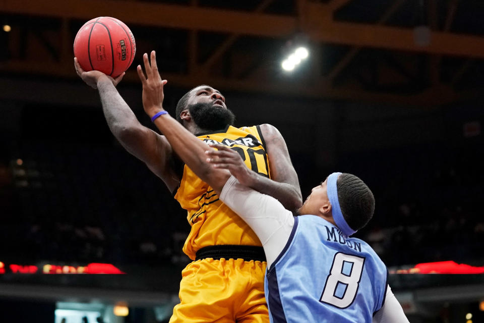 Donte Green hangs in the air with a bastketball in one hand.