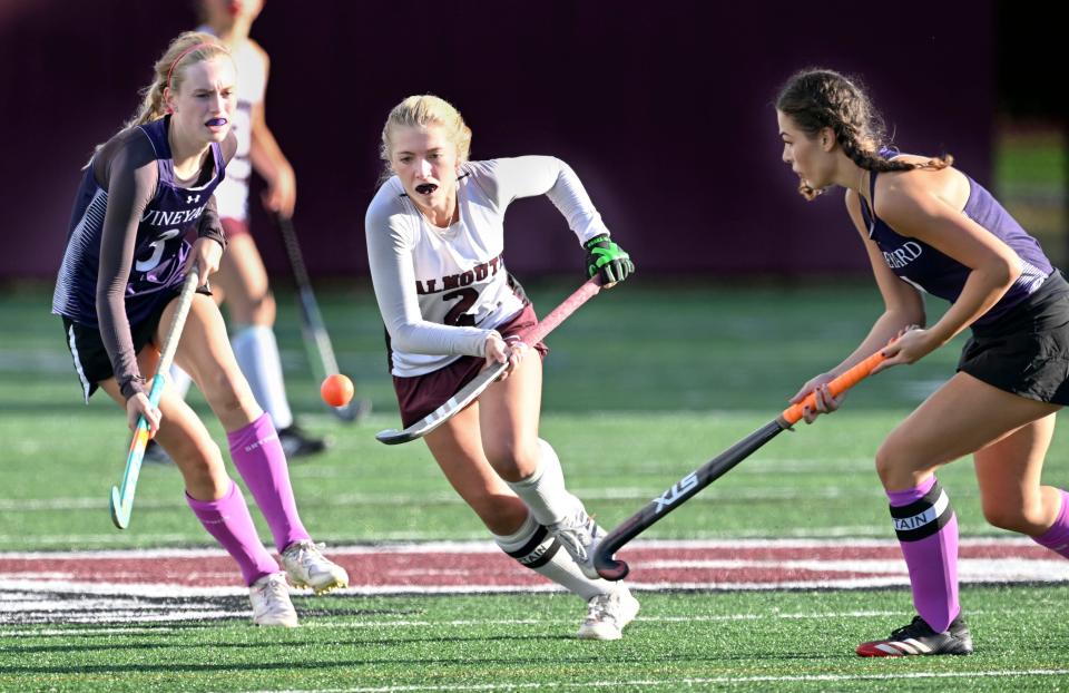 Avery Johnsen of Falmouth moves the ball tapping on her stick between Caroline . Dolby (left) and Sofia Ines Balsas Fuentes of Martha's Vineyard field hockey.