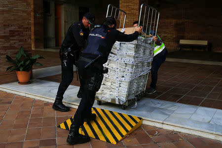 Police push a cart with a portion of the six tonnes of cocaine seized at an industrial estate prior to a press display of confiscated drugs and other material siezed in the operation at the police headquarters in Malaga, Spain, October 25, 2018. REUTERS/Jon Nazca