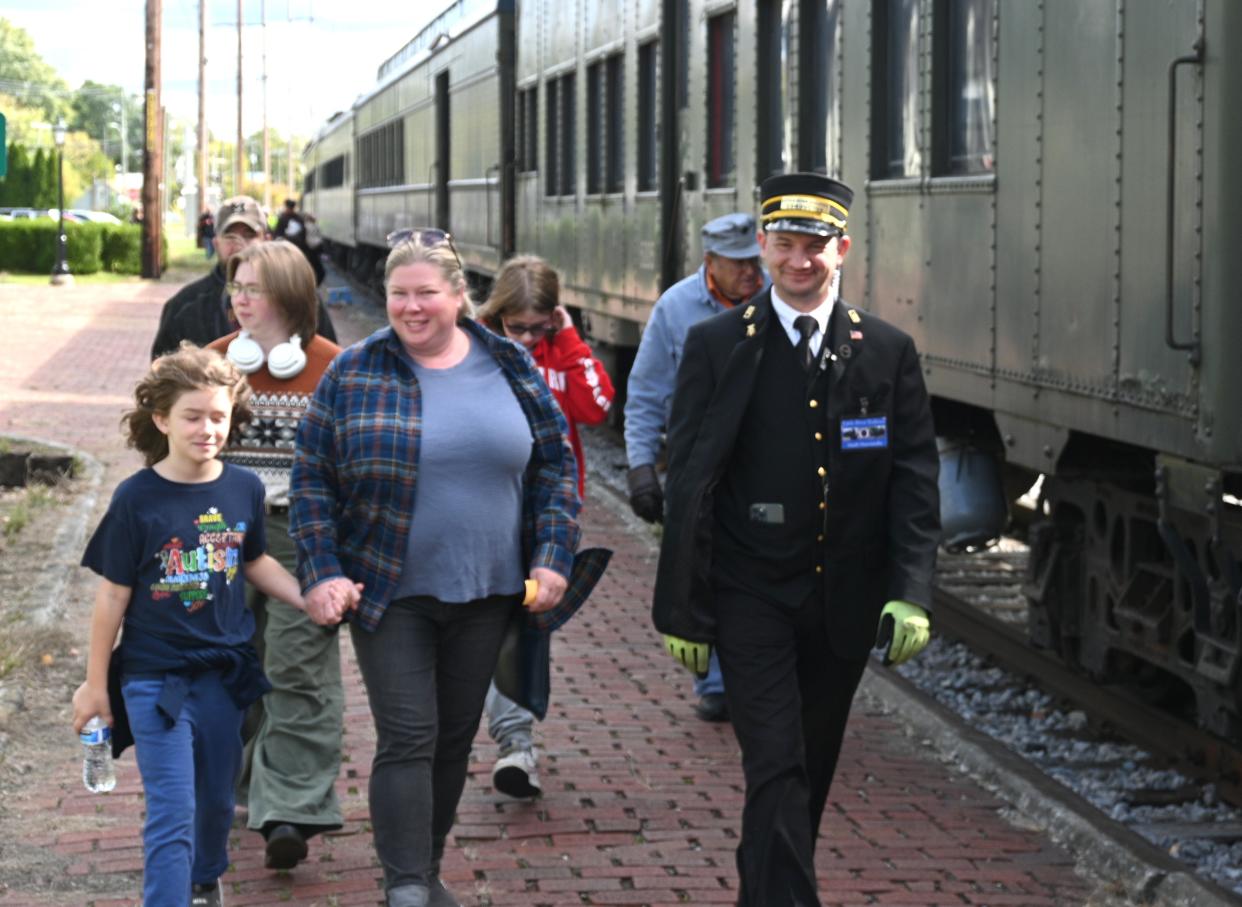 Volunteers help guide passengers to their cars for rides on the steam train at the Coldwater rail station.