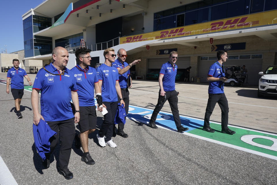 Haas driver Mick Schumacher, third from left, of Germany, walks down pit lane with his team before the Formula One U.S. Grand Prix auto race at the Circuit of the Americas, Thursday, Oct. 20, 2022, in Austin, Texas. (AP Photo/Darron Cummings)