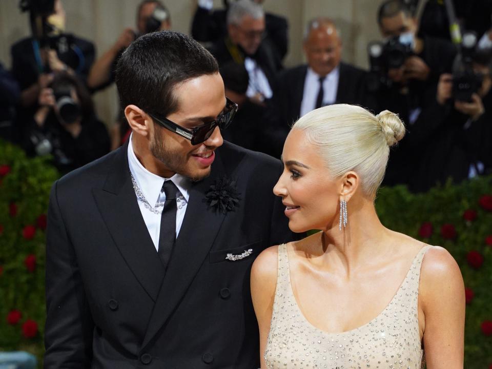 Pete Davidson and Kim Kardashian look at each other on the Met Gala steps.