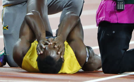 Atletismo - Campeonato Mundial de Atletismo - Final Posta Masculina 4x100 Metros - Estadio de Londres, Londres, Reino Unido – 12 de agosto, 2017. Usan Bolt de Jamaica reacciona después de sufrir una lesión. REUTERS/Lucy Nicholson