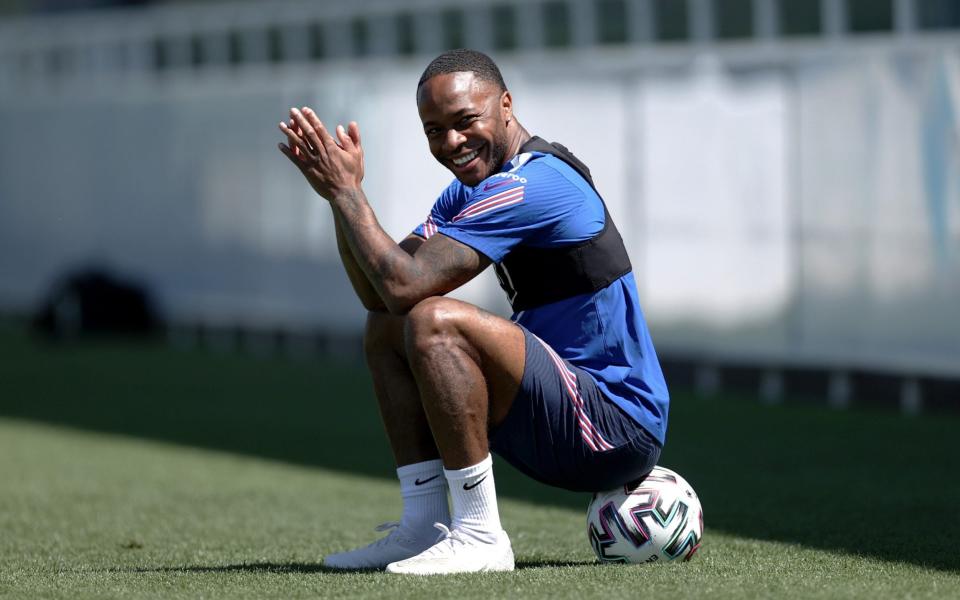 Raheem Sterling sits on the ball during a training session at St George's Park - GETTY IMAGES