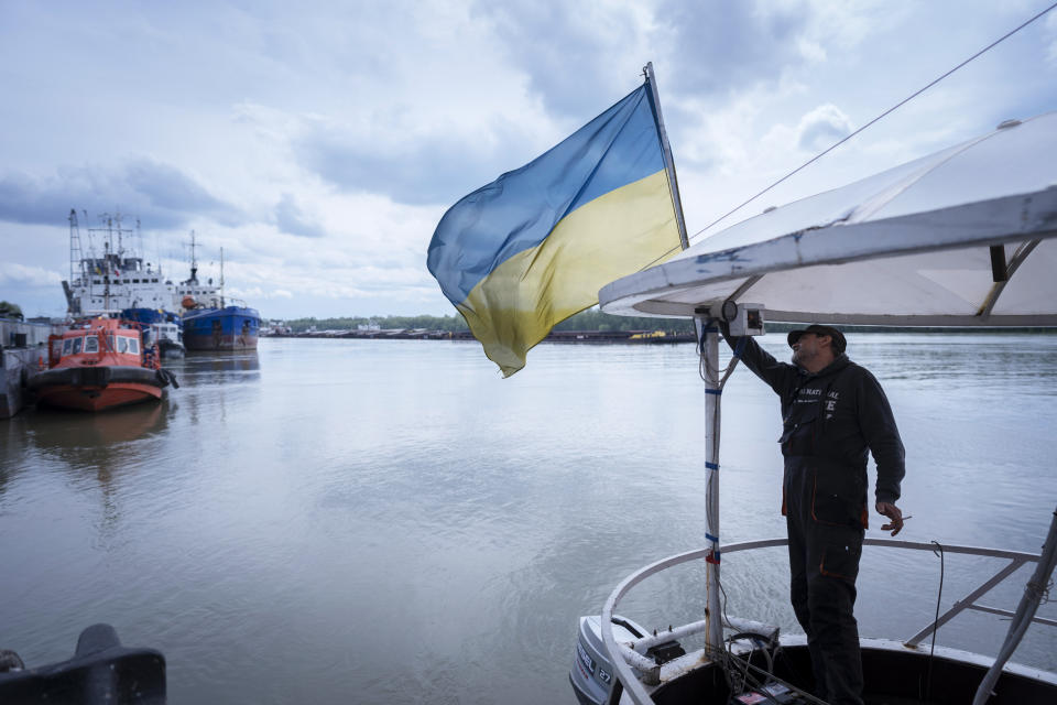 FILE - A sailor fixes the flag of Ukraine on a boat in Izmail, 700 km (432 miles) southwest of Kiev, Ukraine, on April 26, 2023. The United Nations is racing to extend a deal that has allowed for shipments of Ukrainian grain through the Black Sea to parts of the world struggling with hunger, helping ease a global food crisis exacerbated by the war that Russia launched more than a year ago.(AP Photo/Andrew Kravchenko, File)