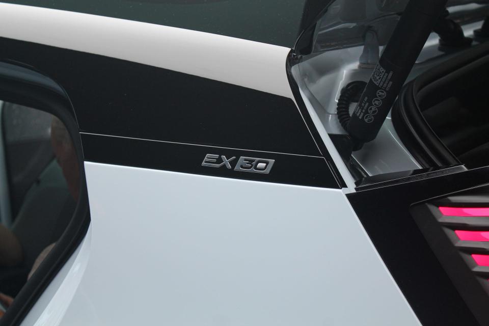 The back left of the Volvo EX30, which has its boot open and "EX30" written on the side in sleek-looking lettering.