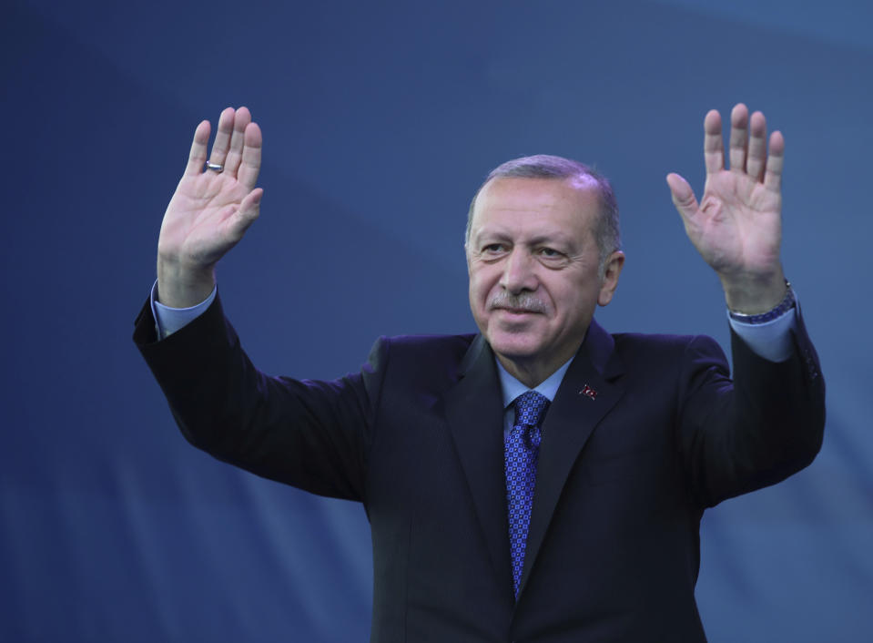 Turkey's President Recep Tayyip Erdogan waves as he attends a ceremony to inaugurate a Turkey-financed highway linking Belgrade with Bosnia's capital of Sarajevo in Sremska Raca, some 80 kilometers (49 miles) west of Belgrade, Serbia, during his two-day official visit, Tuesday, Oct. 8, 2019. The White House said Sunday that U.S. forces in northeast Syria will move aside and clear the way for an expected Turkish assault, essentially abandoning Kurdish fighters who fought alongside American forces in the years long battle to defeat Islamic State militants. Erdogan has threatened for months to launch the military operation across the border as he views the Kurdish forces as a threat to his country. (Presidential Press Service via AP, Pool)