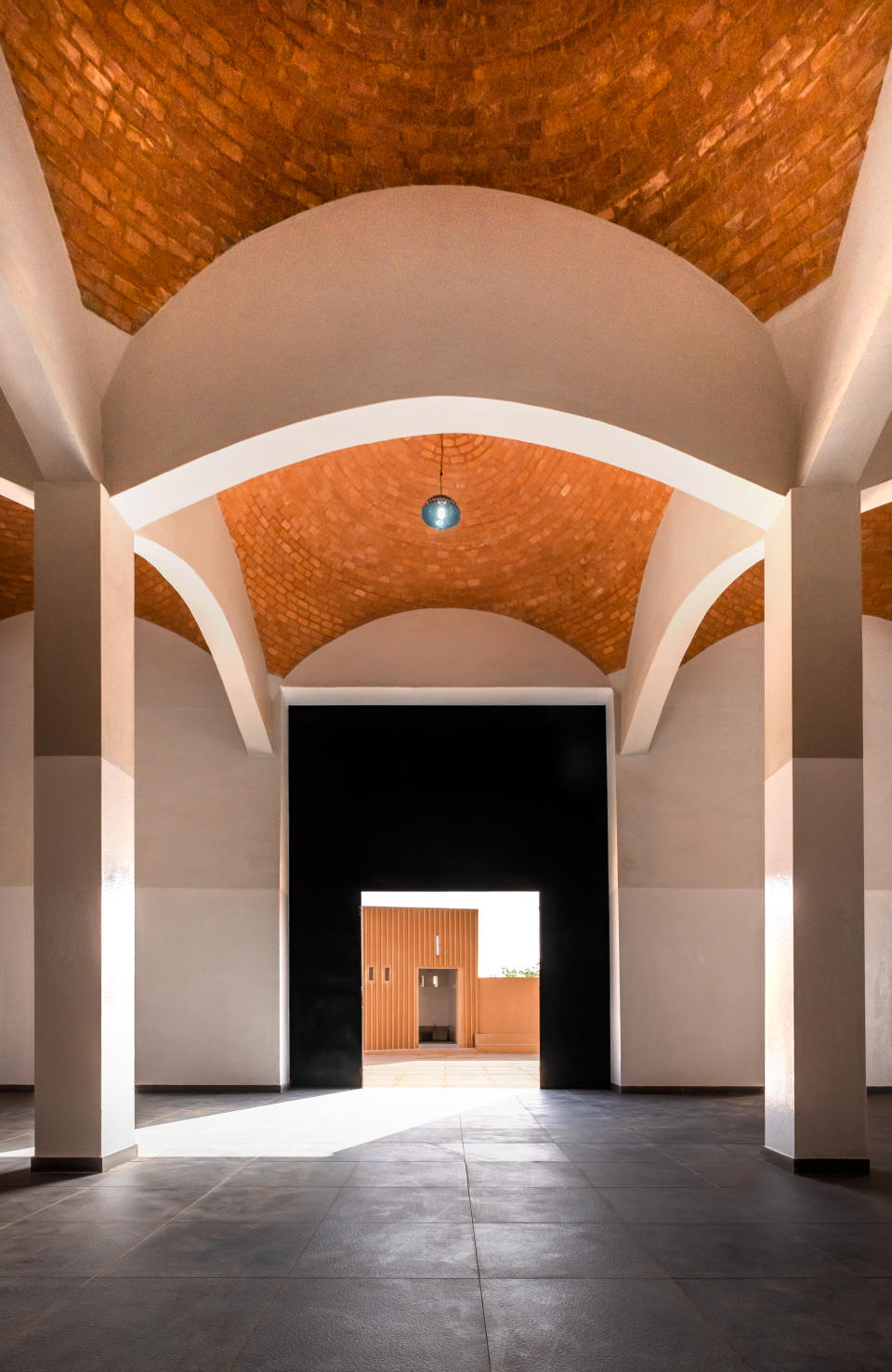 A view through a corridor featuring architectural high ceilings at Hikma Religious-Secular Complex in Dandaji, Niger by Mariam Kamara.