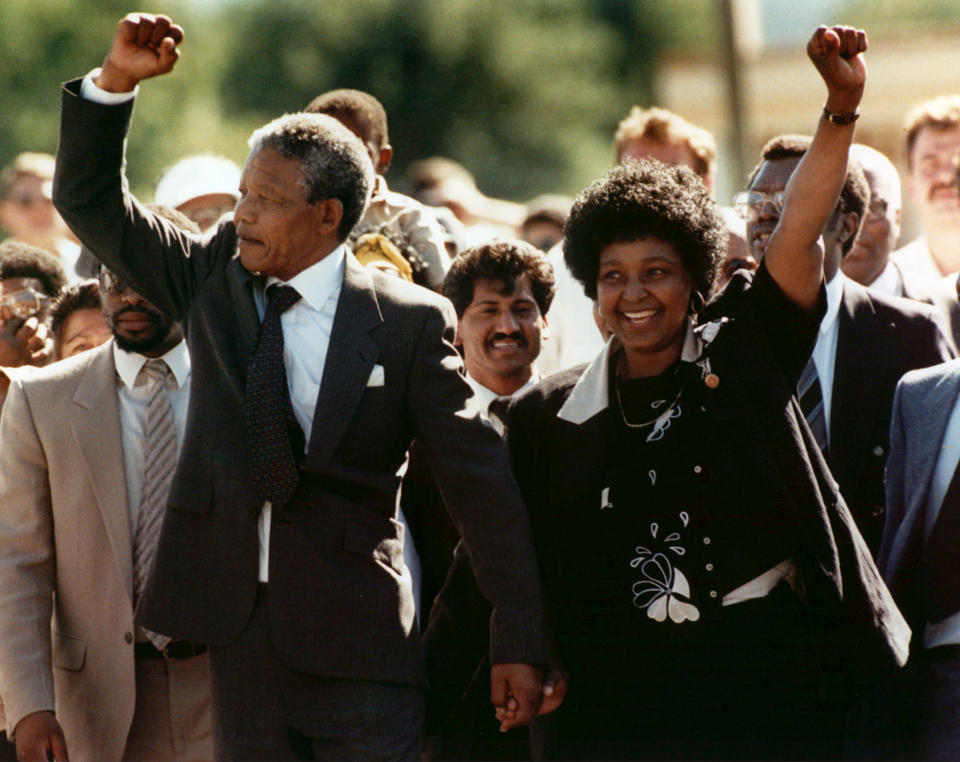 Nelson Mandela y su esposa Winnie caminan de la mano con los puños levantados a su salida de prisión en Ciudad del Cabo, el domingo 11 de febrero de 1990. El líder del Congreso Nacional Africano había cumplido más de 27 años de prisión. (Foto AP)