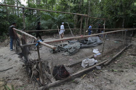 Security forces and rescue workers inspect an abandoned camp at a rubber plantation near a mountain in Thailand's southern Songkhla province May 7, 2015. REUTERS/Surapan Boonthanom