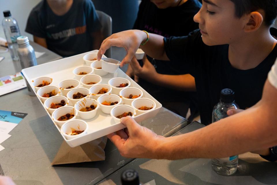 Attendees grab from a tray of sago worm chili samples at BUGfest at the Natural History Museum of Utah in Salt Lake City on Saturday.