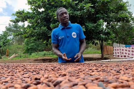 Ghanian cocoa farmer, Aziz Kwadio, 34, speaks during an interview with Reuters as he dries cocoa beans at his farm in the village of Essam