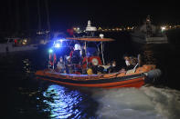 People are evacuated by boat after wildfires reached the Kemerkoy Power Plant, a coal-fueled power plant, in Milas in southwest Turkey, late Wednesday, Aug. 4, 2021. (AP Photo/Cem Tekkesoglu)