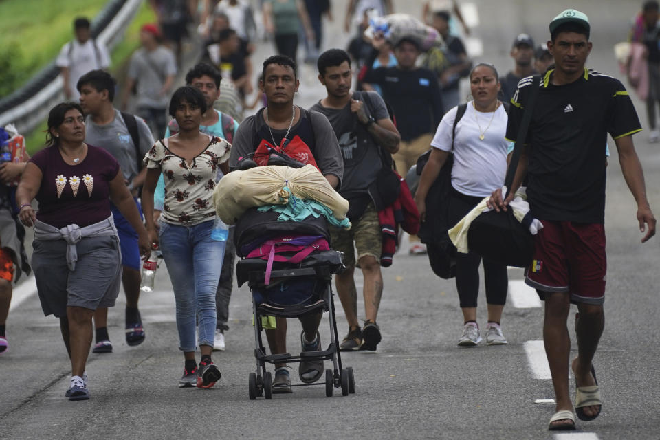 Migrants walk on the highway toward the exit to Huixtla, Chiapas state, Mexico, early Thursday, June 9, 2022. The group of migrants left Tapachula on Monday, tired of waiting to normalize their status in a region with little work, with the ultimate goal of reaching the U.S. (AP Photo/Marco Ugarte)