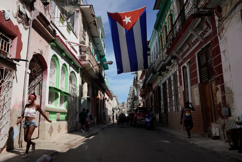 FILE PHOTO: People walk under a Cuban flag in downtown Havana