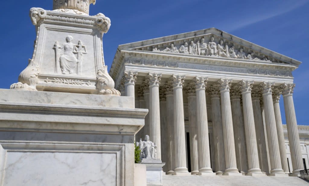 The U.S. Supreme Court is seen, with a carving of Justice in the foreground, April 19, 2023, in Washington. (AP Photo/Jacquelyn Martin, File)