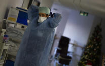 A Belgian Army medic suits up as she prepares to deliver lunch to patients with COVID-19 at the St. Michiel Hospital in Brussels, Tuesday, Nov. 24, 2020. The Belgian military has been called into several hospitals and care homes to alleviate the stress on healthcare personnel. (AP Photo/Virginia Mayo)