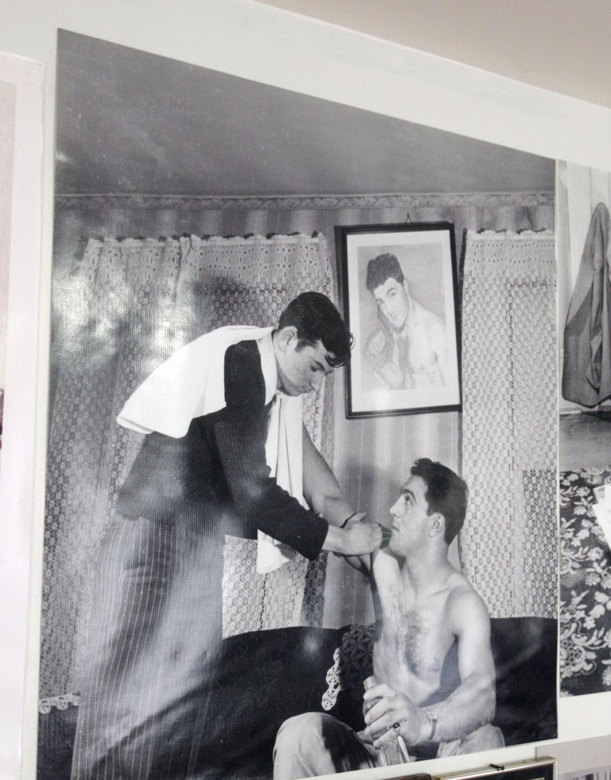According to the Marciano house's current owner Mark Casieri, the heavyweight champ built a ring in his backyard to train, and his trainers would come to work with him. In this photograph which hangs in the living room, one of his handlers gives him a rub down after a workout. Seen on Monday, April 29, 2024.