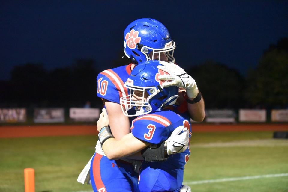 Lenawee Christian's Sam Lutz (3) and Easton Boggs (10) hug after a touchdown pass between the two during Friday's game against Mendon.