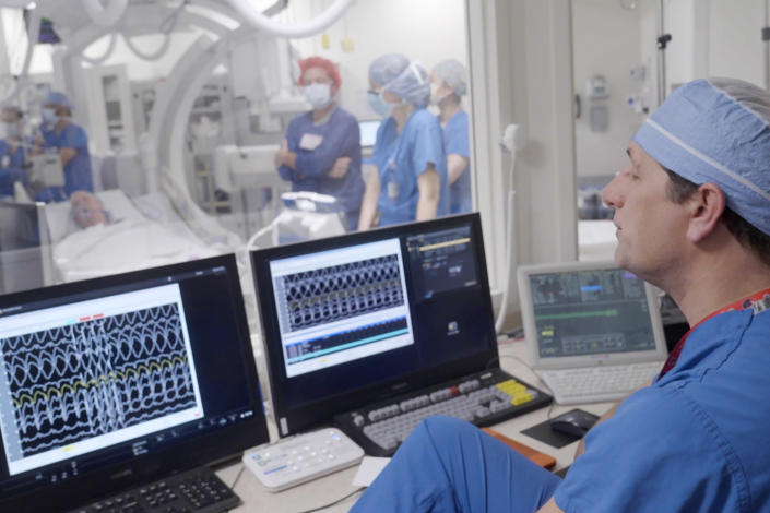 In this photo provided by Washington University, Dr. Phillip Cuculich works with others to prepare for an experimental treatment using radiation for Jeff Backus' irregular heartbeat in St. Louis on Tuesday, Feb. 7, 2023. Detailed medical scans give Cuculich a three-dimensional map pinpointing where the heartbeat goes awry. (Huy Mach/Washington University, St. Louis via AP)