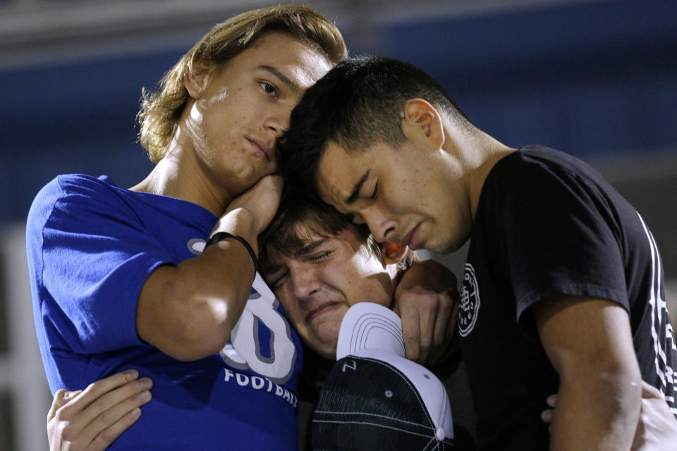 <p>Daniel Friesenhahn (C) is comforted by Derrick Barnhardt (R) and Chris Johnson during a vigil in the memory of those killed in the shooting at the First Baptist Church of Sutherland Springs in La Vernia, Texas, Nov. 7, 2017. (Photo: Jonathan Bachman/Reuters) </p>