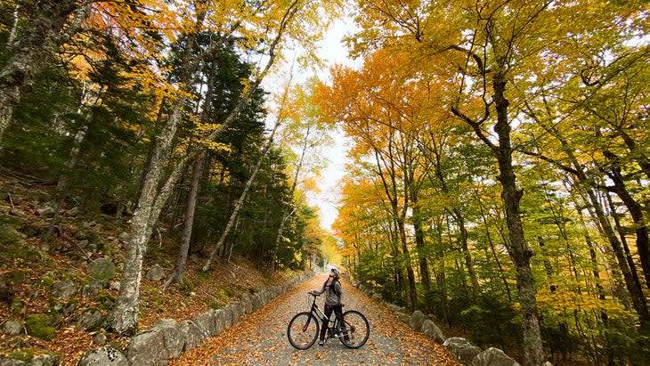 woman on an autumn bike ride on Acadia's carriage roads