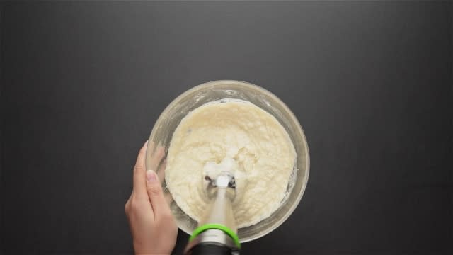Blending durian pulp and thick coconut milk with hand blender